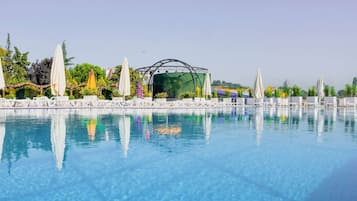 Una piscina techada, sillones reclinables de piscina