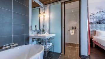 Une salle de bain moderne avec une baignoire sur pieds, un meuble-lavabo avec miroir et un espace douche.