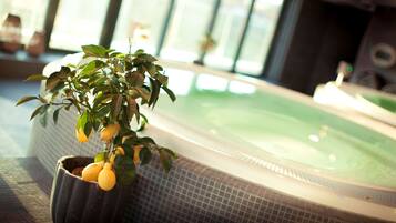 A spa area with a hot tub and a potted lemon tree.