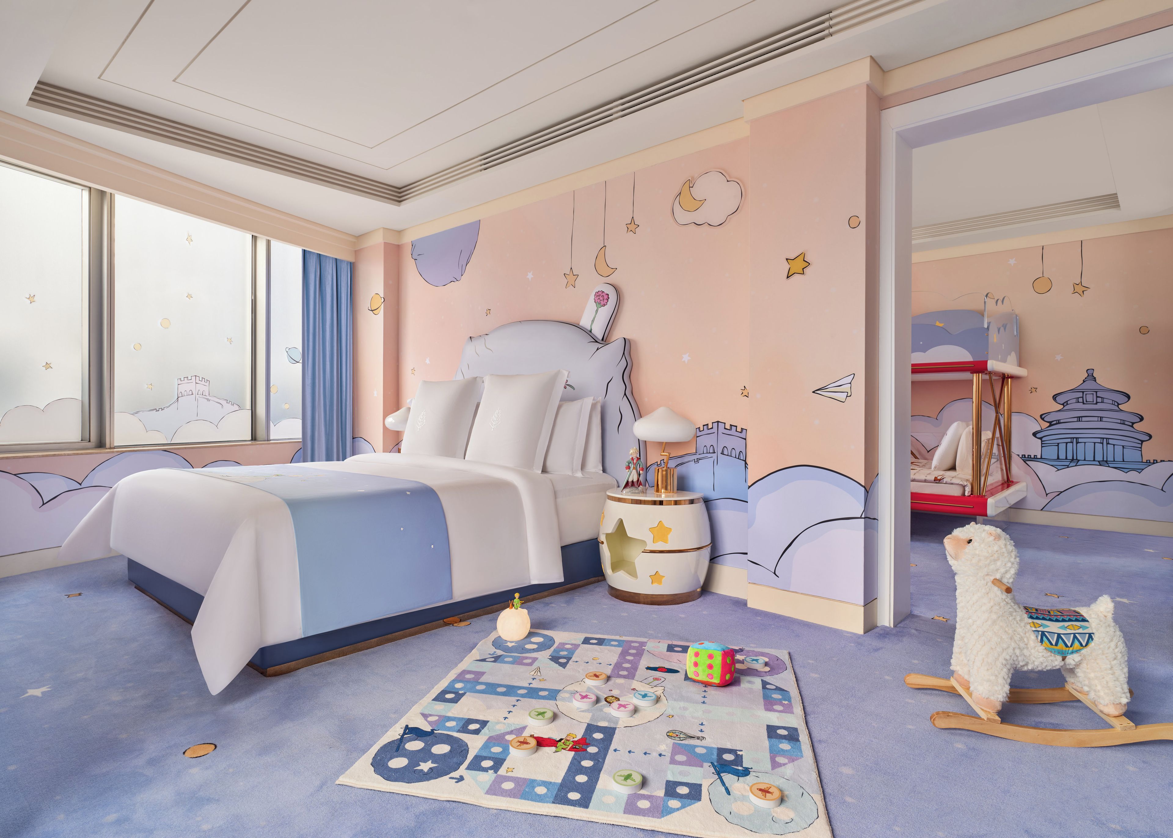 Une chambre d’enfant avec un lit, un jouet et un cheval à bascule.