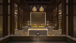 A modern spa area with a central reception desk, a stone-tiled hot tub, and a decorative fountain. - Four Seasons Hotel Beijing (Beijing)