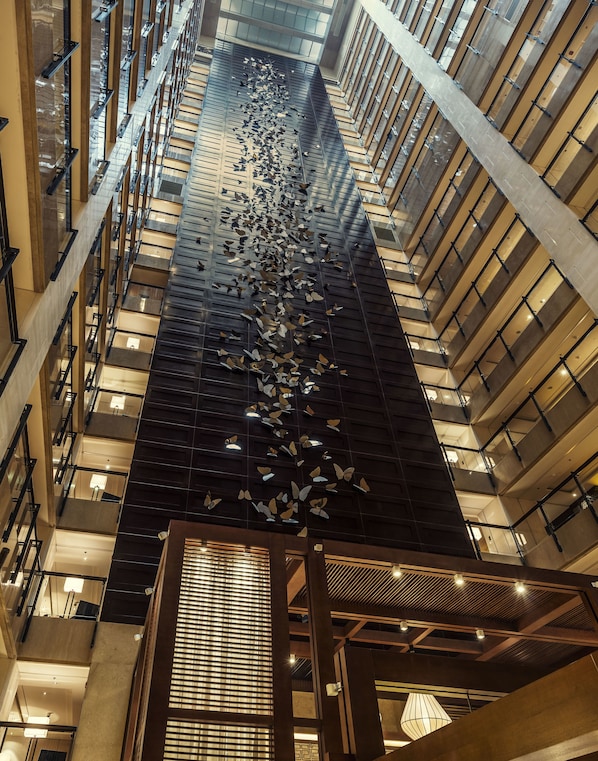 Un edificio de gran altura con un atrio central que presenta una instalación decorativa de mariposas.