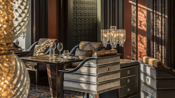 Un'elegante sala da pranzo con tovaglia decorata, sedie raffinate e un lampadario.