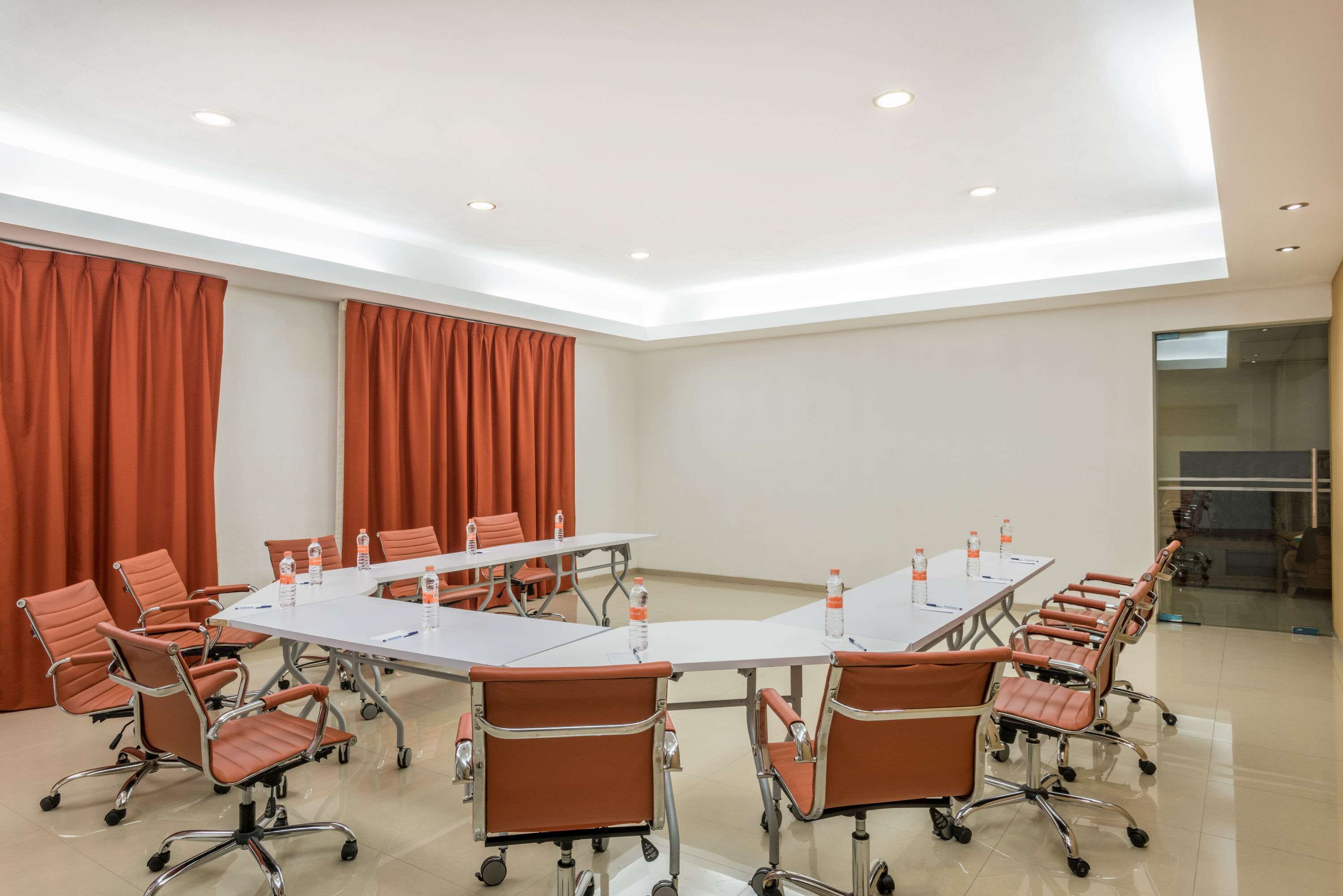 A conference room with a long table, multiple chairs, and water bottles.