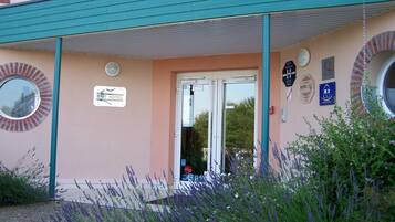 The Brit Hotel entrance with a teal awning, a signboard, and a circular window.