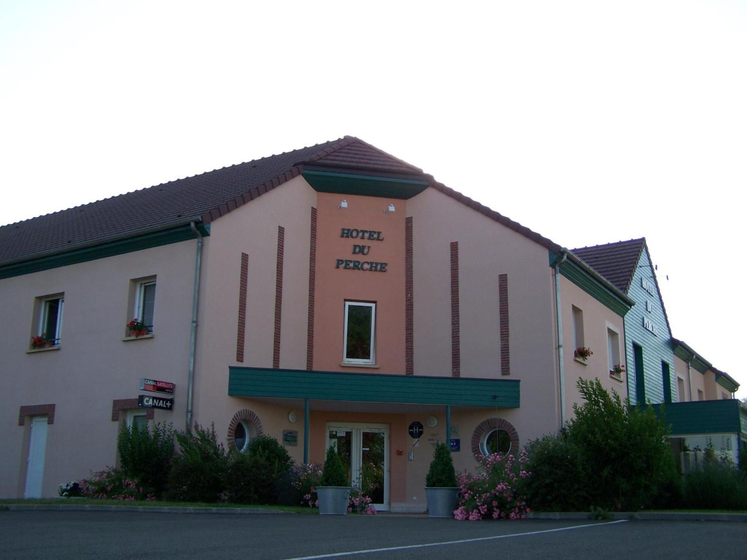 A two-story building with a sign reading "HOTEL DU PERCHE". It has a simple facade with a flat roof and a green awning over the entrance.