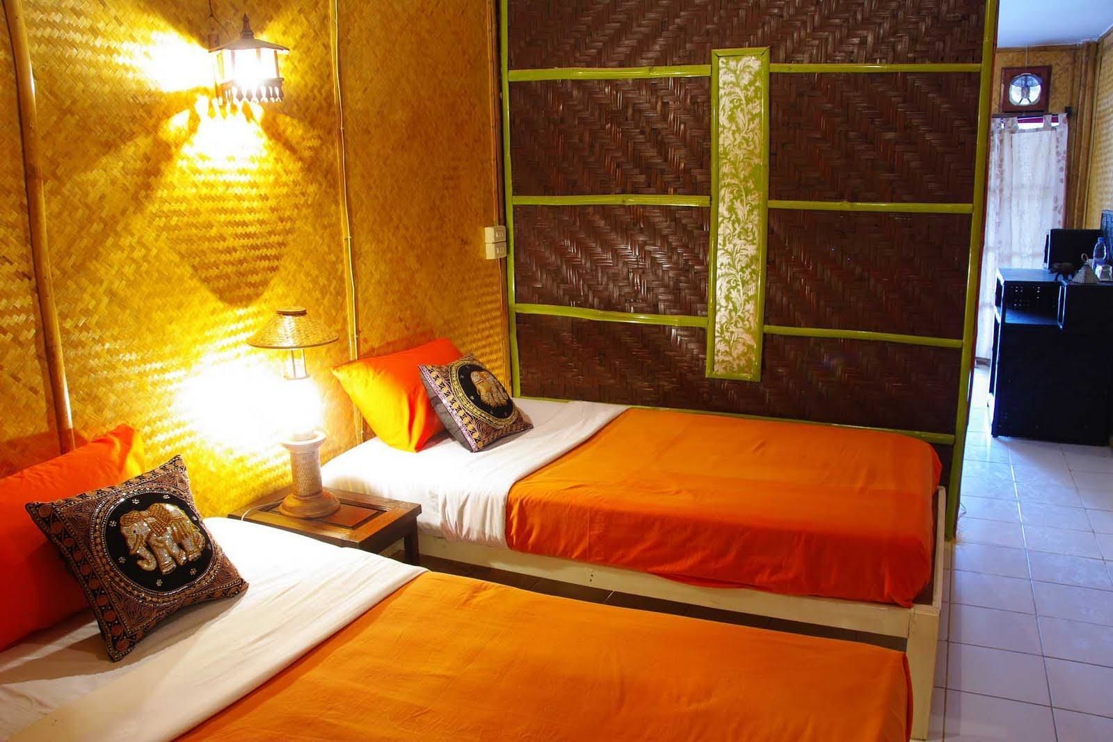 A hotel room with two beds, a nightstand, a lamp, and a decorative wall panel.