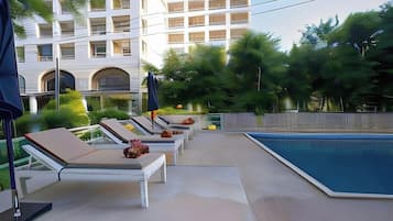 A poolside area with lounge chairs and a swimming pool.