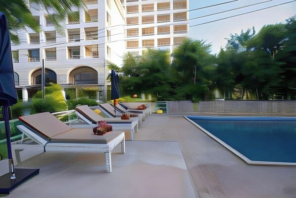 A poolside area with lounge chairs and a swimming pool.