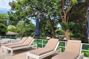 A poolside area with lounge chairs and umbrellas.
