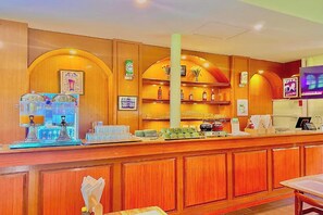 A bar area with wooden paneling, a counter with various bottles, and a television screen. - Hillside Resort Pattaya (Pattaya)