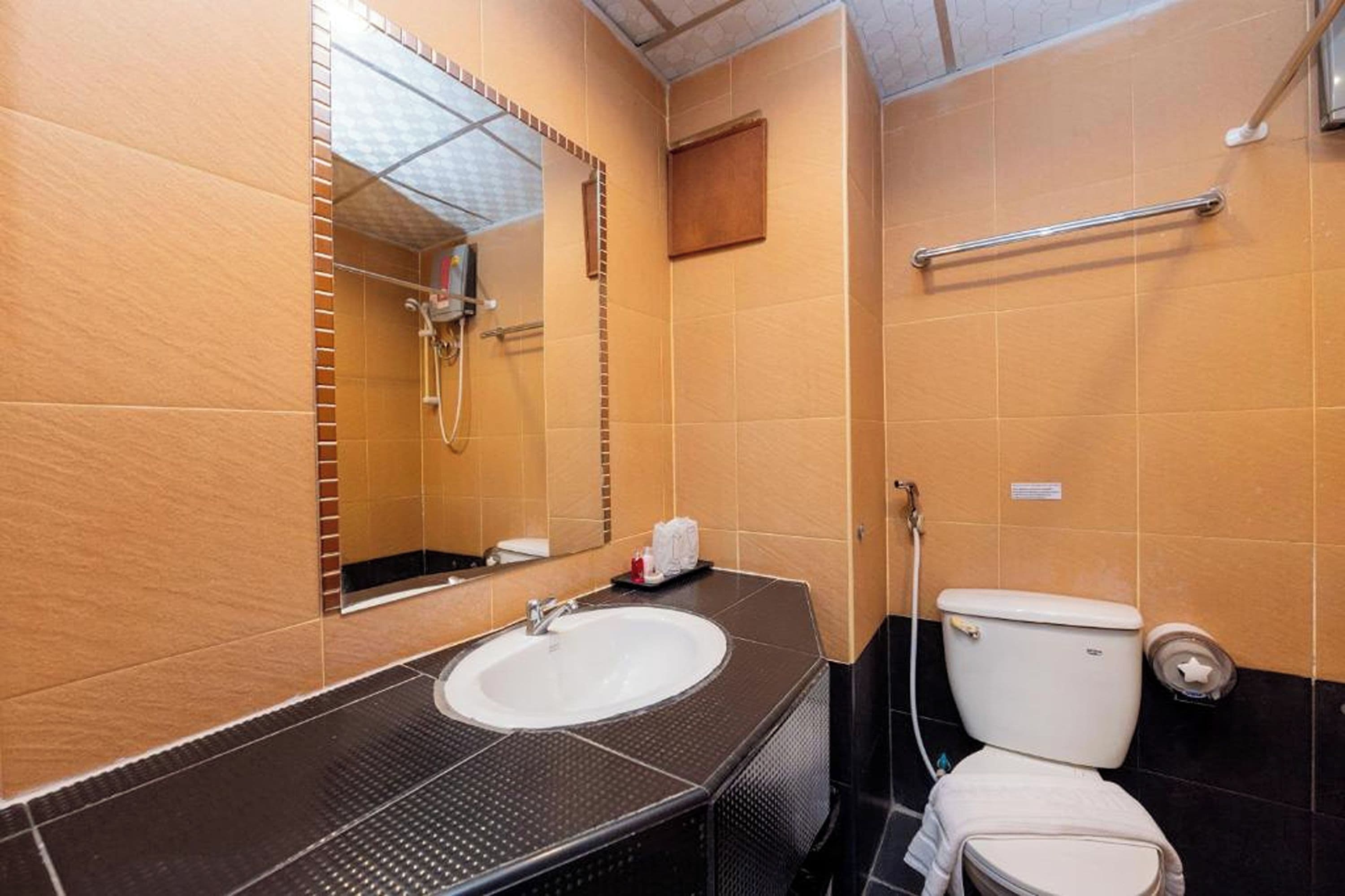 A bathroom with a sink, mirror, toilet, and shower.