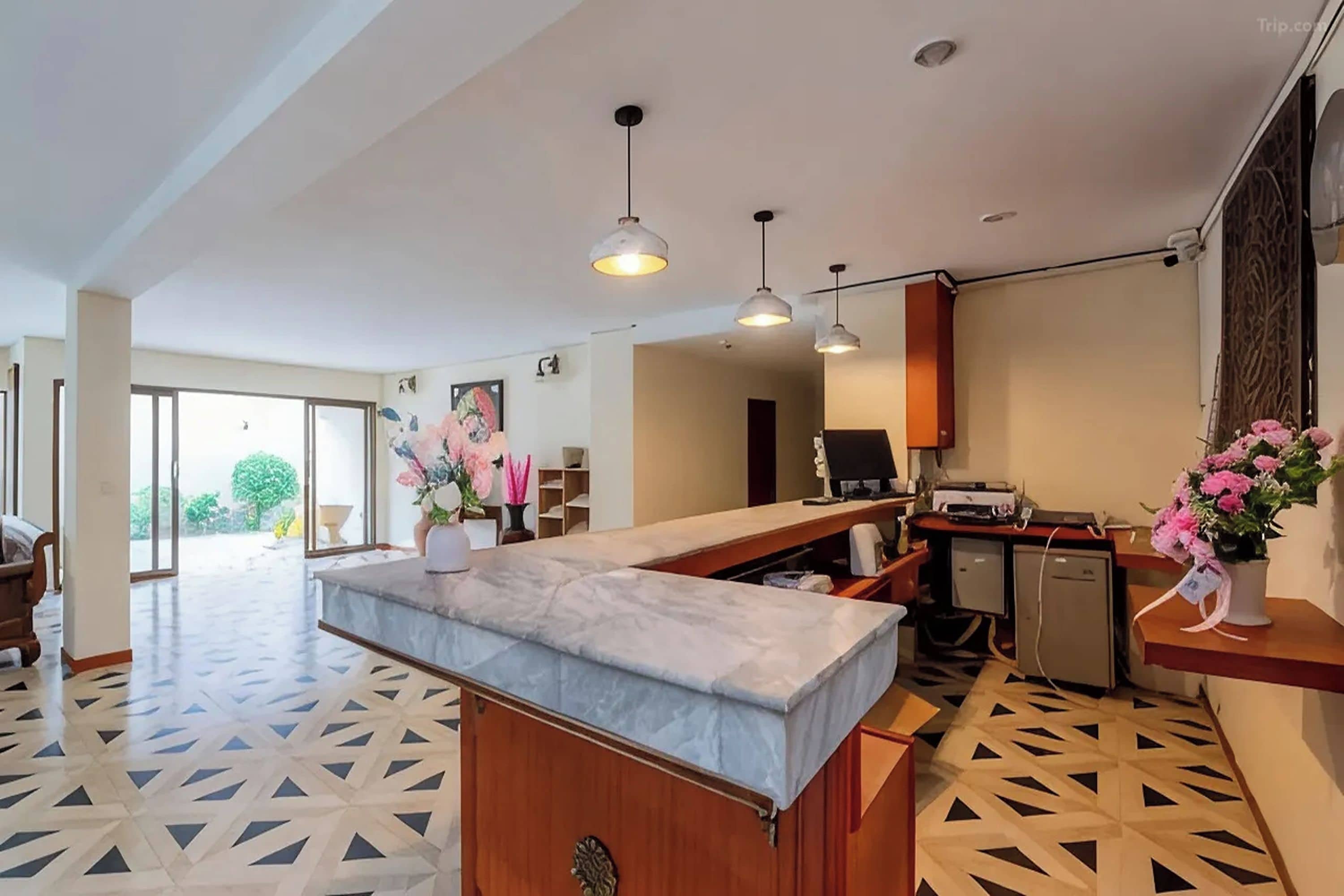 Een moderne keuken met een marmeren aanrechtblad, hanglampen en uitzicht op het buiten.