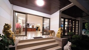 A hotel entrance with a reception desk, a staircase leading to the lobby, and decorative golden statues. - Hillside Resort Pattaya (Pattaya)