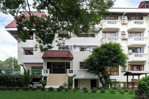 A multi-story building with balconies, a central entrance with steps, and a surrounding garden. - Hillside Resort Pattaya (Pattaya)