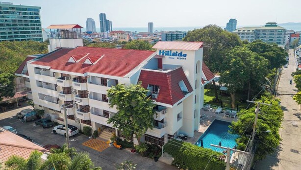 A multi-story hotel with a red roof and a swimming pool. - Hillside Resort Pattaya (Pattaya)