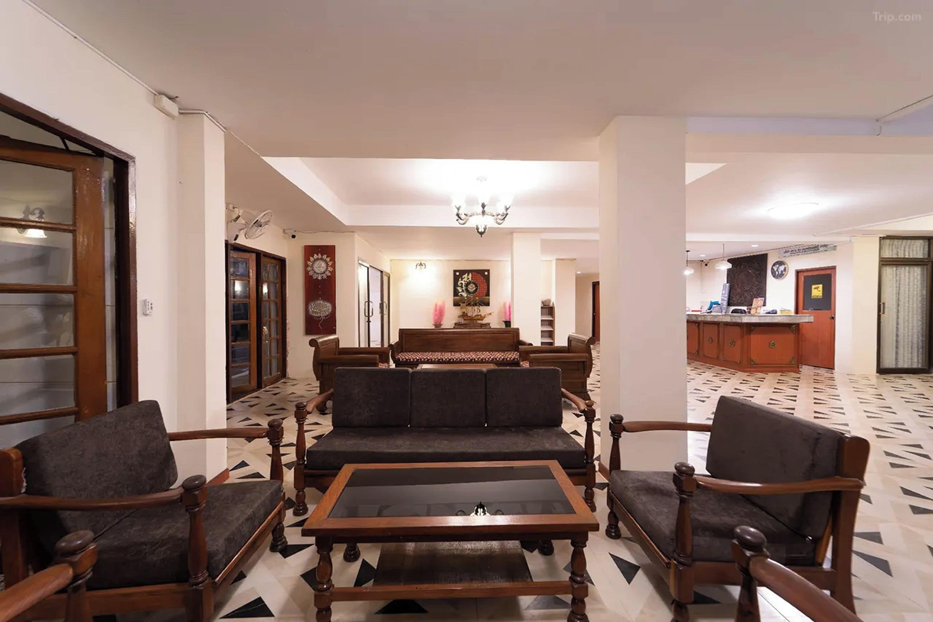 A living room with a sofa set, a coffee table, and a dining area with a chandelier.