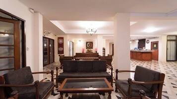 A living room with a sofa set, a coffee table, and a dining area with a chandelier.