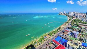 A coastal cityscape with a clear view of the ocean, boats, and a mix of urban and residential buildings. - Hillside Resort Pattaya (Pattaya)