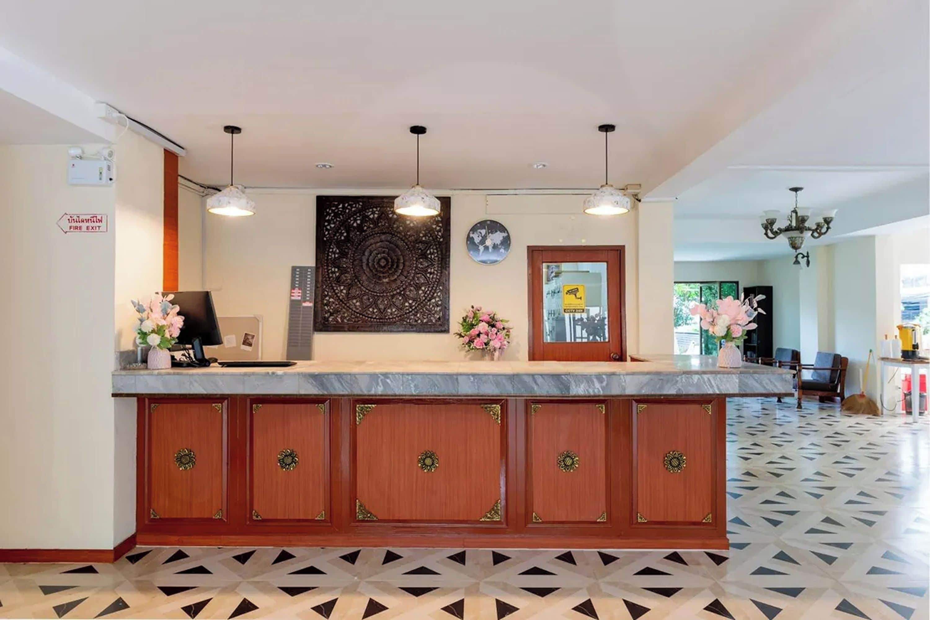 A reception desk with a world map, a fire exit sign, and a patterned floor.