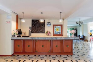 A reception desk with a world map, a fire exit sign, and a patterned floor. - Hillside Resort (Pattaya)