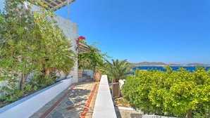 A pathway leading to a building with a view of the sea.