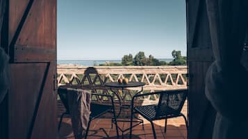 Enjoy a tranquil sea view from this outdoor space with a table and chairs.