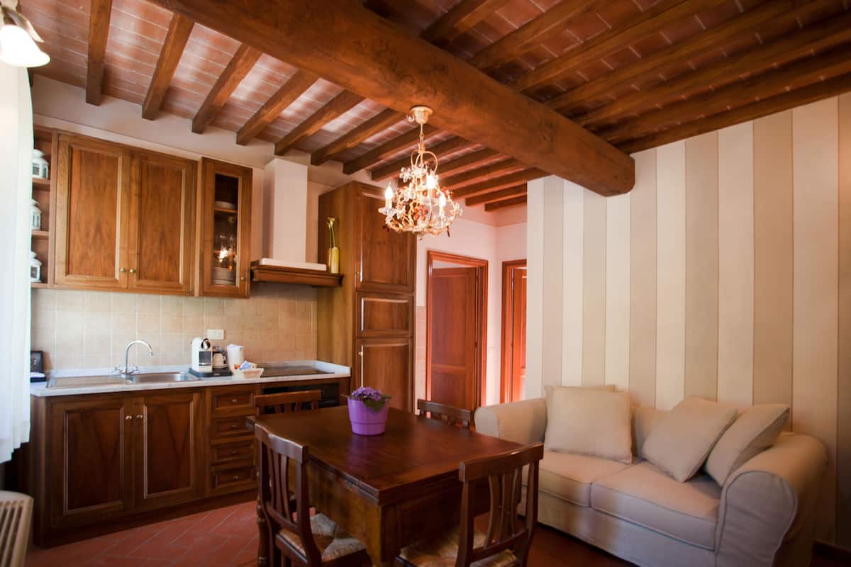 A kitchen with wooden cabinets, a dining table, and a chandelier.