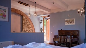 A bedroom with a stone archway, a wooden dresser, and a chandelier. - Relais Villa Belvedere (Figline e Incisa Valdarno)