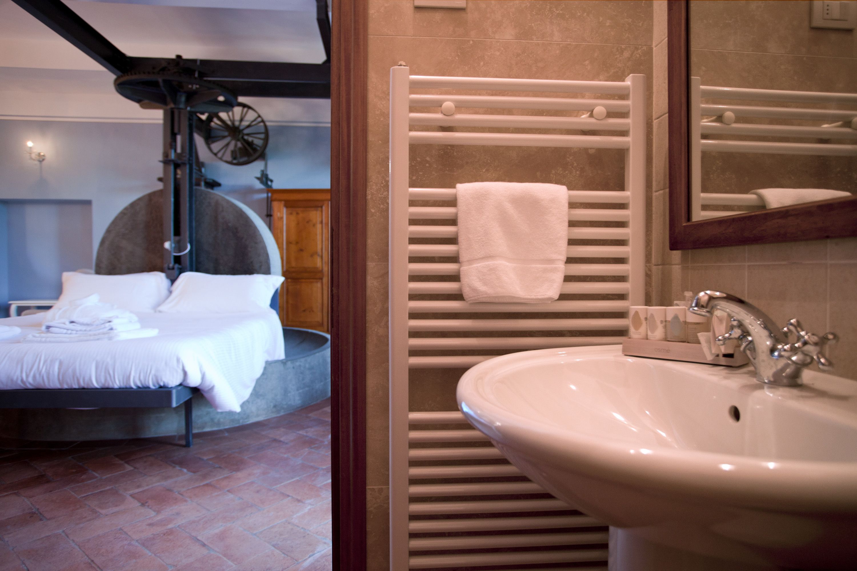 A modern bathroom with a white sink, towel rack, and a mirror.