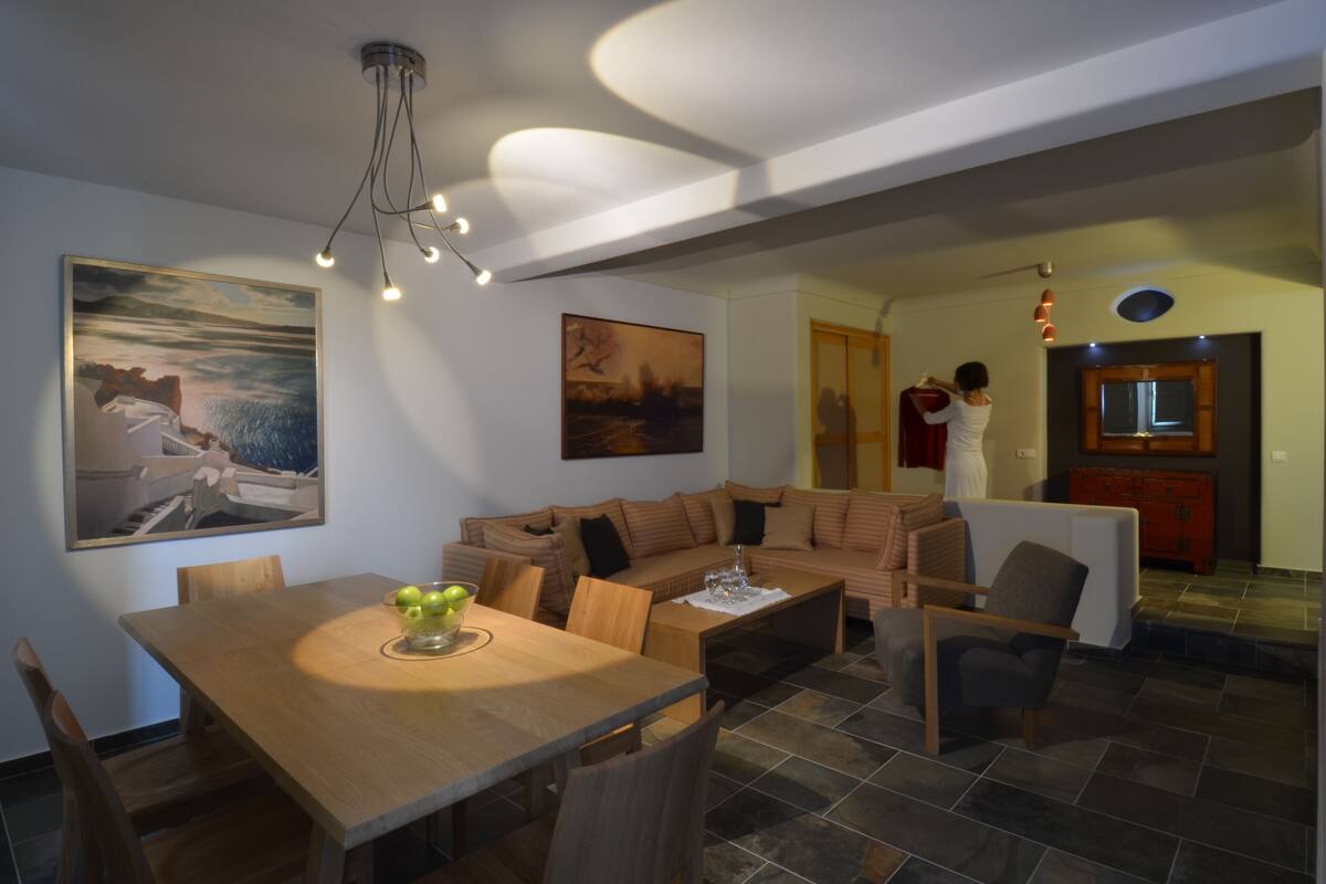Una sala moderna con una mesa de comedor de madera, un sofá y un televisor.