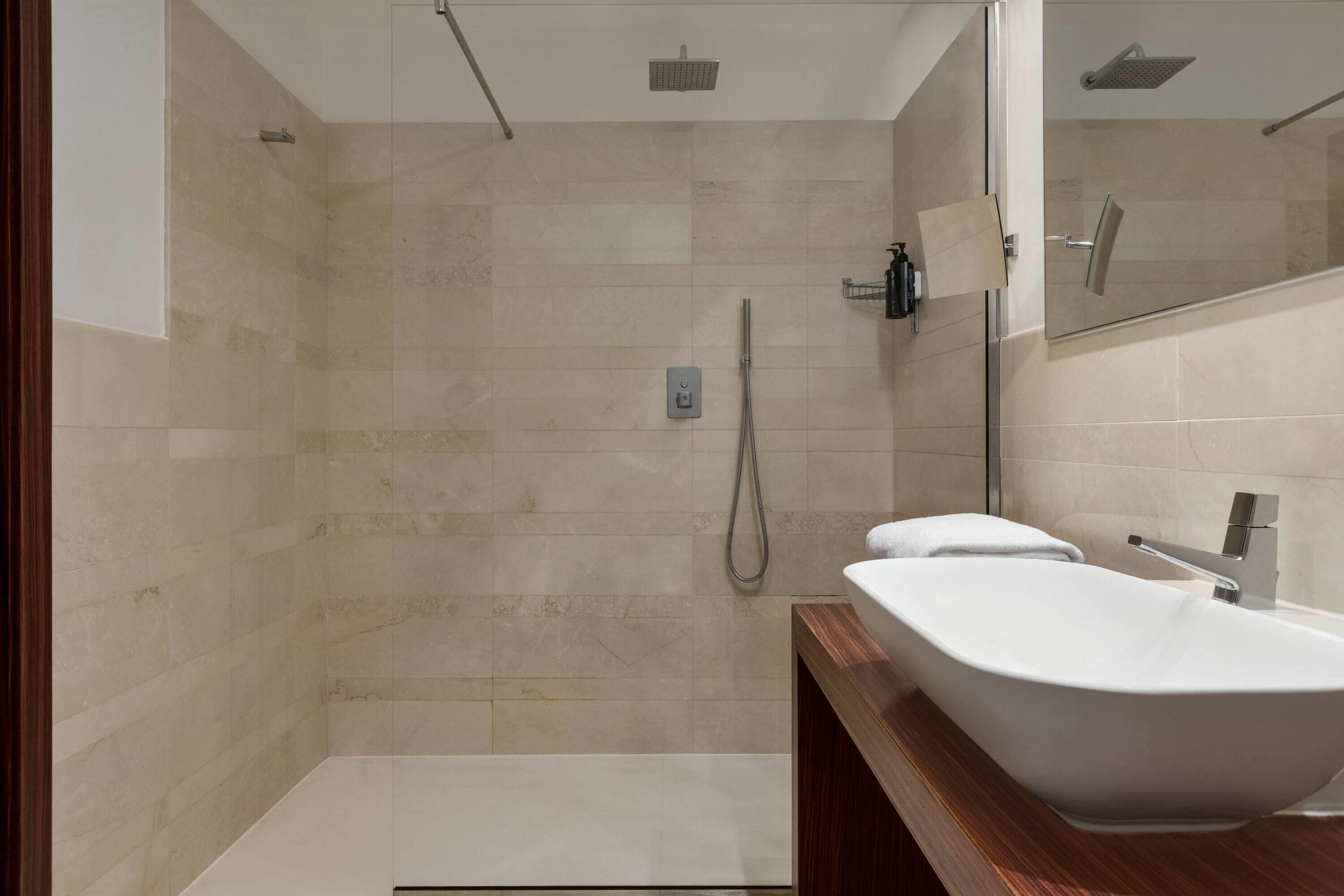 Un bagno moderno con una vasca da bagno indipendente, una zona doccia e uno specchio grande.