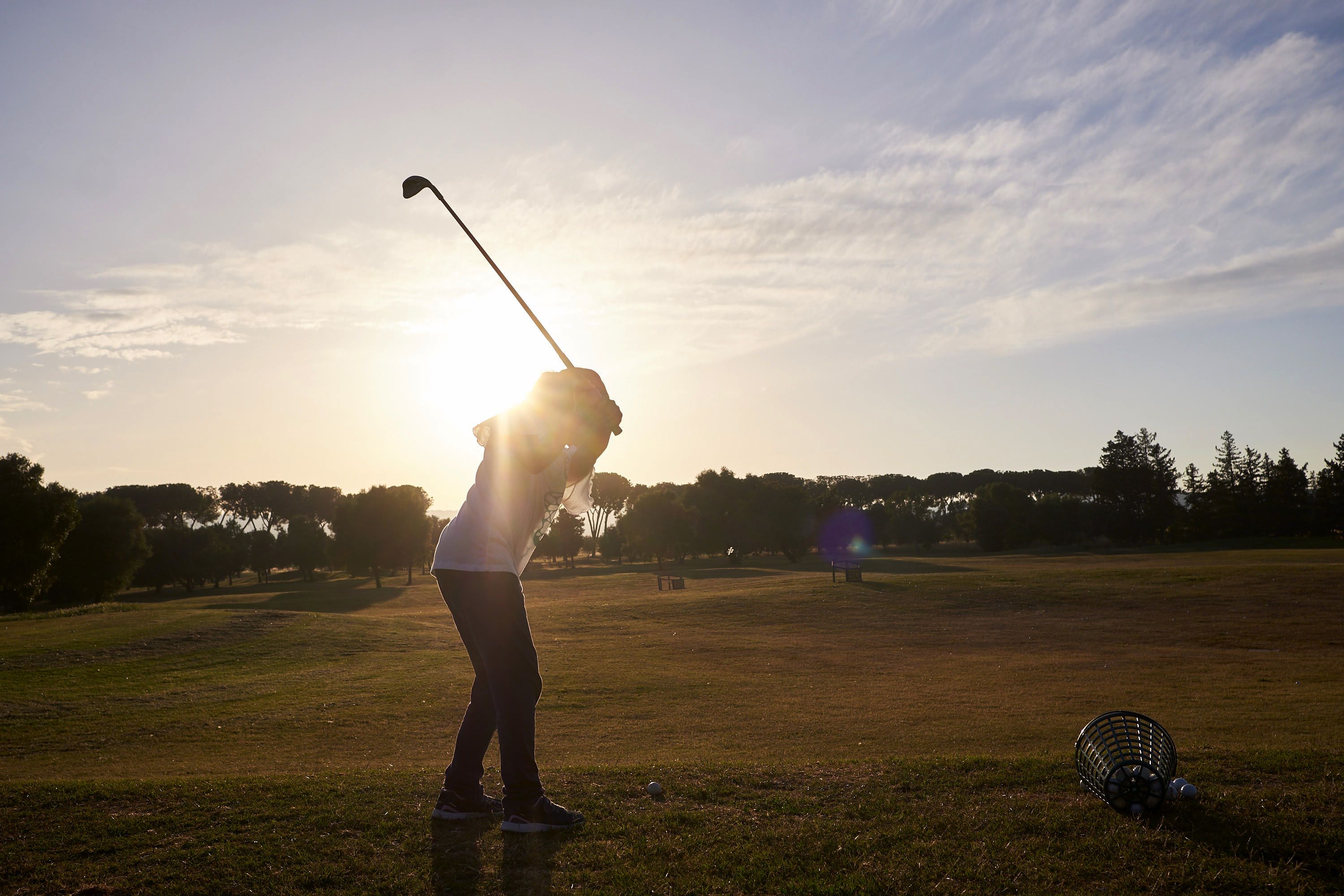 A person playing golf on a sunny day.