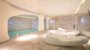 A modern spa with a large indoor pool, a separate relaxation area with a whirlpool, and a glass partition. - Dolce by Wyndham Siracusa I Monasteri Golf & Spa (Syracuse)