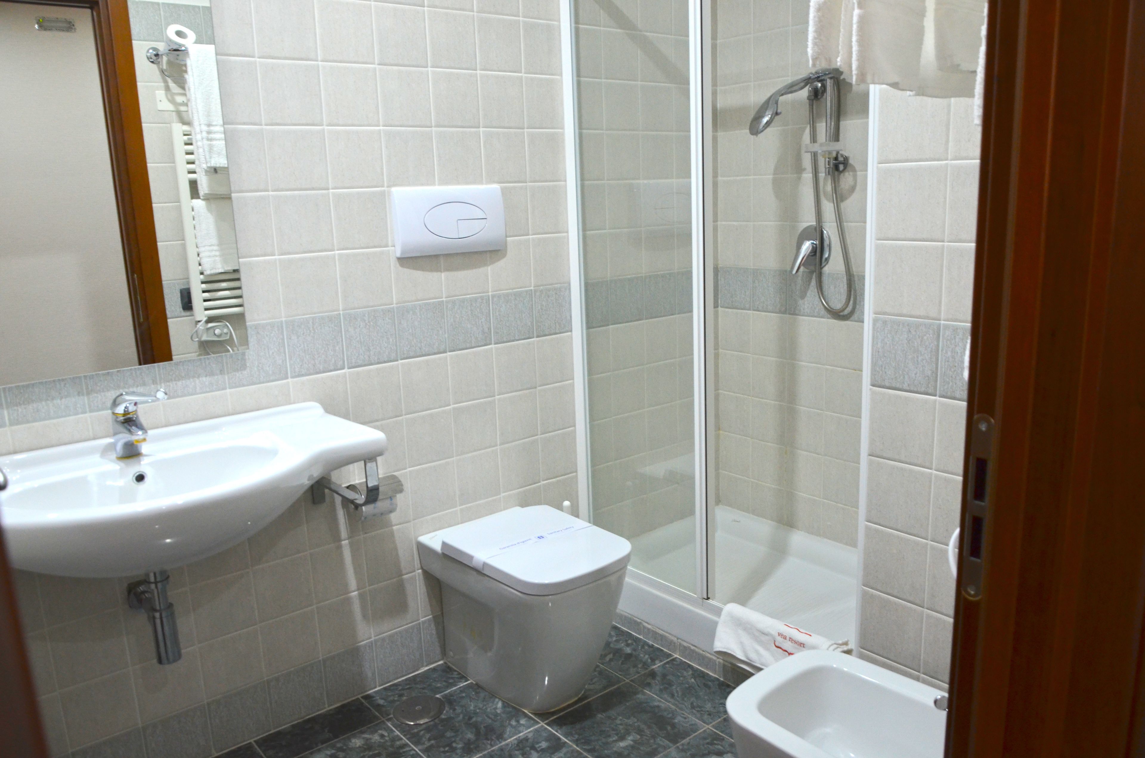 A bathroom with a sink, toilet, and shower.