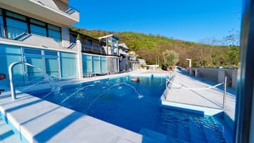 Una piscina al aire libre, sombrillas