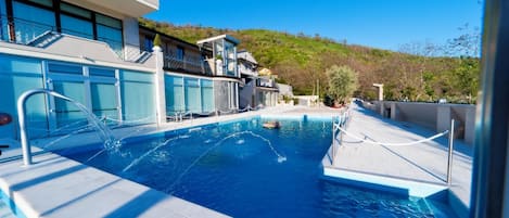 Una piscina al aire libre, sombrillas