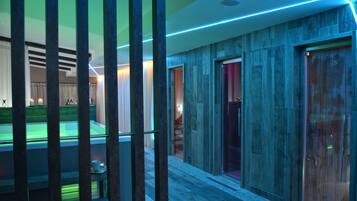 Un hall d’hôtel moderne doté d’un espace piscine, de lambris en bois et d’un ascenseur en verre.