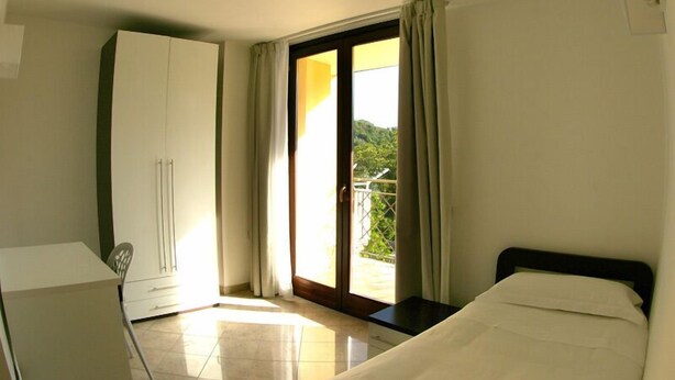 Una habitación con cama, armario, mesa y silla.