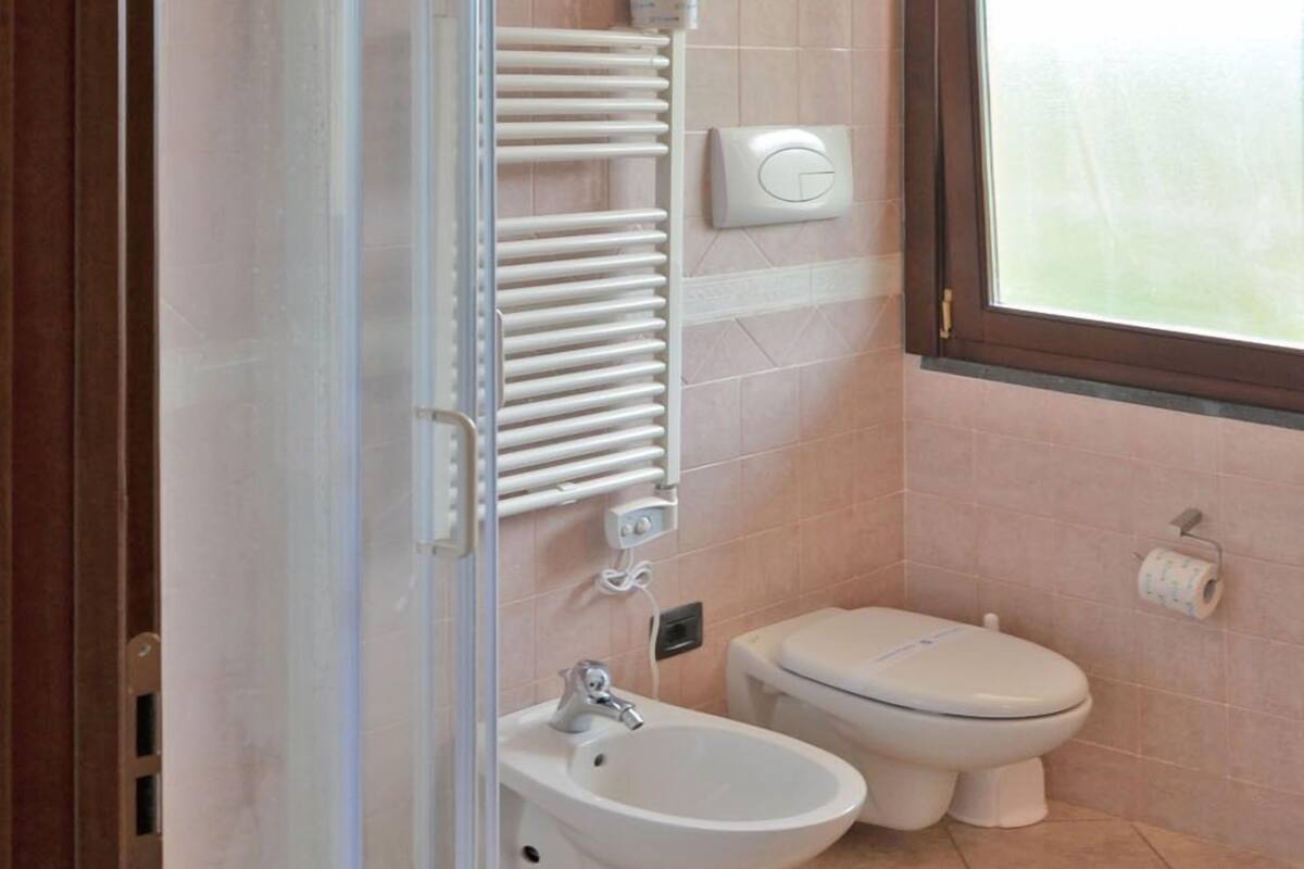 A modern bathroom with a shower, bidet, sink, and toilet.