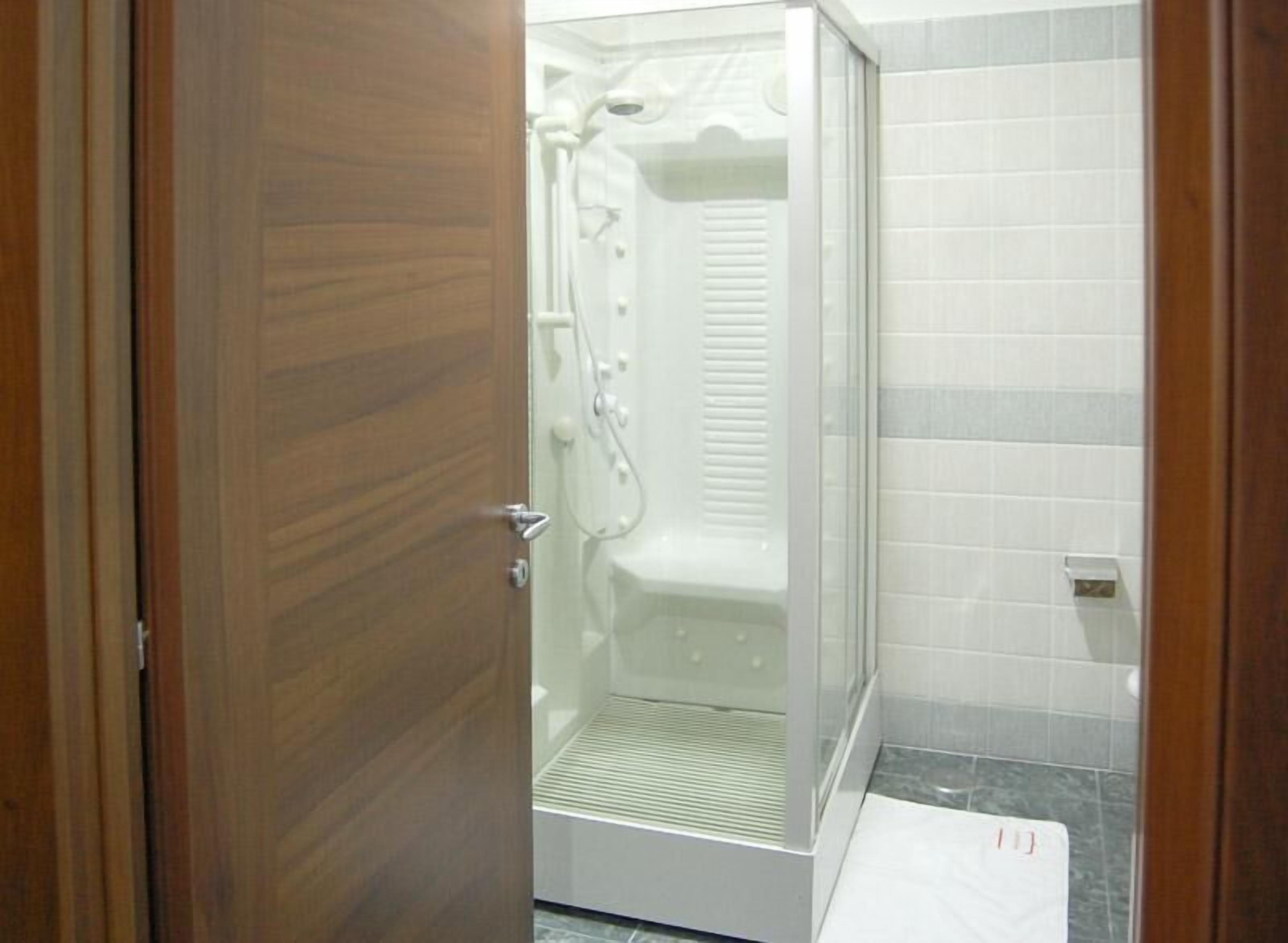 A bathroom with a shower, a toilet, and a sink.