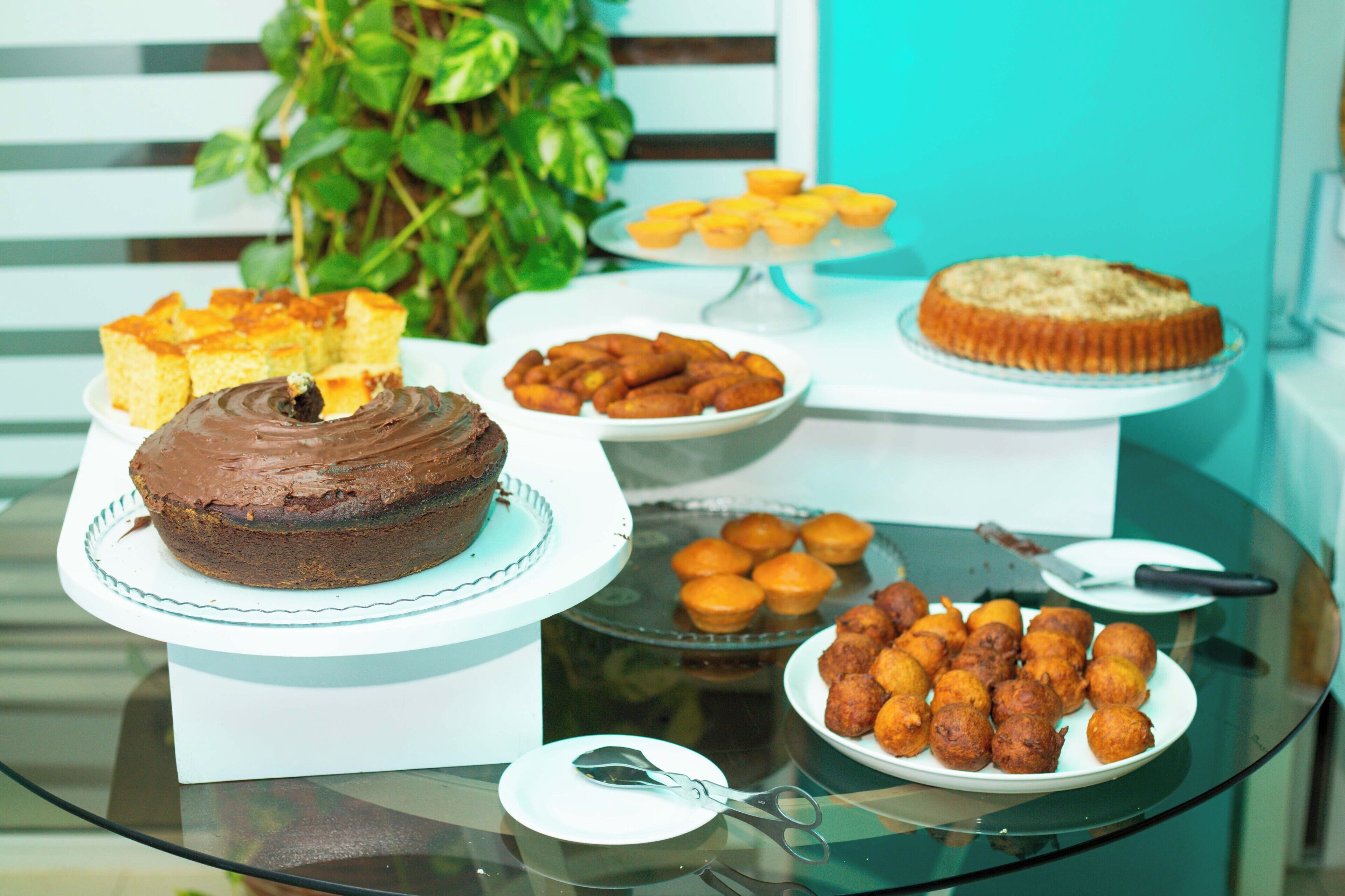 A glass table with various desserts including a chocolate cake, cupcakes, and pastries.