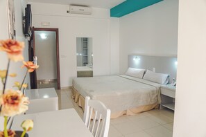 A modern hotel room with a bed, bedside table, and a mirror.