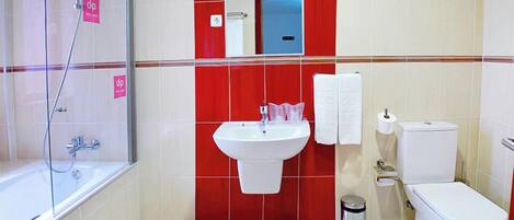 A bathroom with a shower, sink, toilet, and a mirror.