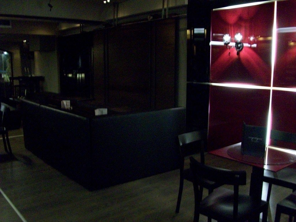 A dimly lit bar area with a counter and seating.