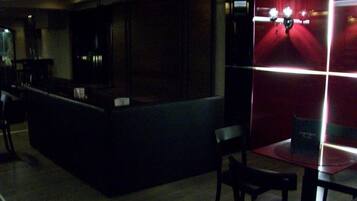 A dimly lit bar area with a counter and seating.