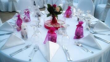 A round table set for a formal event with numbered place settings, clear glassware, and decorative centerpieces.