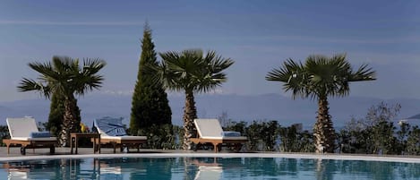 Piscine couverte, piscine extérieure, parasols de plage, chaises longues