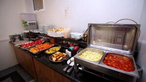 Un bufé con diversos alimentos, entre ellos frutas, verduras y platos preparados.