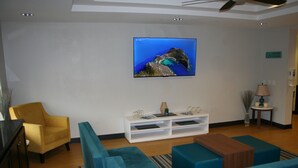Una sala de estar moderna con un sofá, una mesa de centro y un televisor montado en la pared.